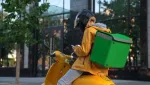 delivery courier with a yellow coat and bike, with a green delivery bag