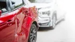 red and silver car in a accident, the red car has a dent in the back 