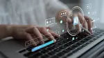 person typing holding a stylus with AI symbols floating across laptop keyboard