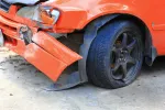 orange car with visible crash damage in the front