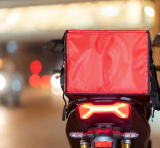 photo of a delivery driver with a red box of food