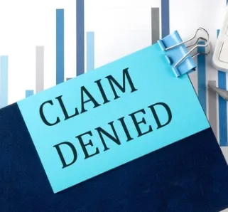 claim denied on a blue sticky note on a clipboard 