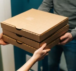 courier deliverying boxes of pizza to someone at their door