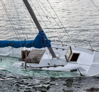 white boat capsizing in water