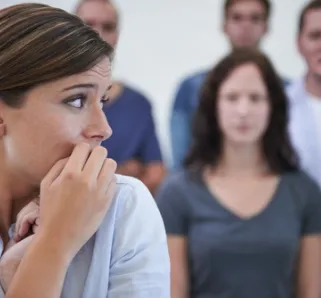 person nervously looking away with people behind them, staring at them