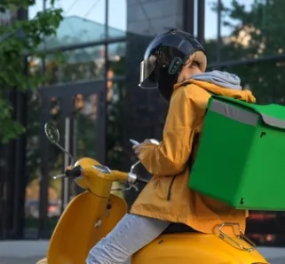 delivery courier with a yellow coat and bike, with a green delivery bag