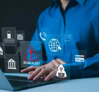 person sitting in front of laptop with a variety of icons with a scam icon in red popping up