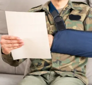 veteran in a arm sling reading a claim paper