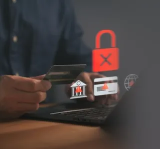 person sitting in front of laptop with error messages, holding a credit card and their phone in hand