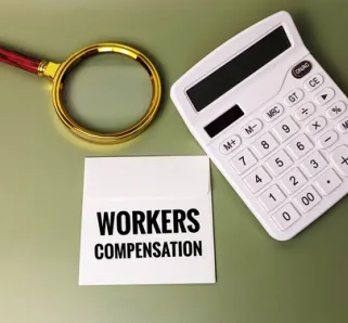 magnifying glass with calculator and notepad that reads 'workers compensation' 