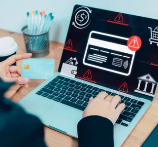 person sitting in front of laptop with error messages holding their card