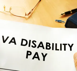 veterans affairs disability pay displayed on pile of papers that someone is holding.