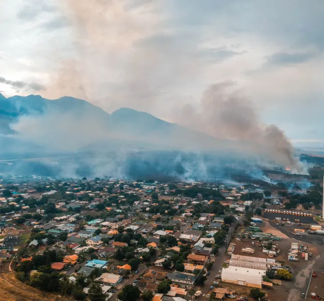 Arial view of smoke rising from a residential area in Maui due to wildfires