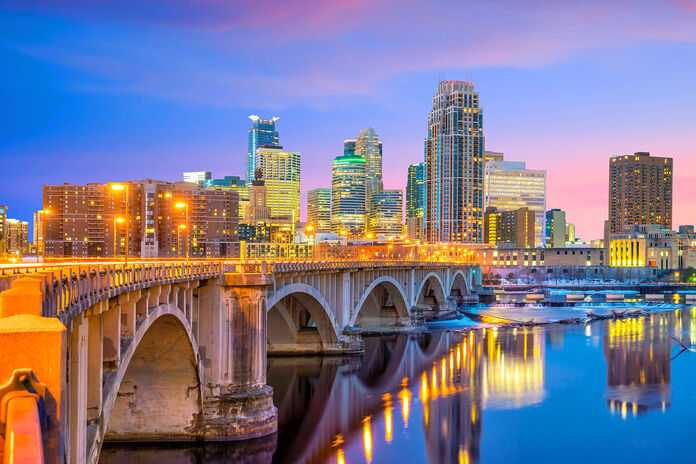 Evening lights illuminate Minneapolis and the Stone Arch Bridge, a vibrant setting for personal injury lawyers.