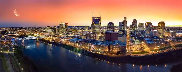 Nashville skyline at sunset reflecting in the river, a vibrant scene for personal injury lawyers.