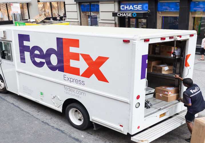 Fedex driver taking packages from van