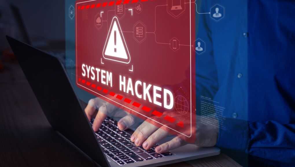 Cybersecurity alert with a holographic system hacked warning on laptop screen