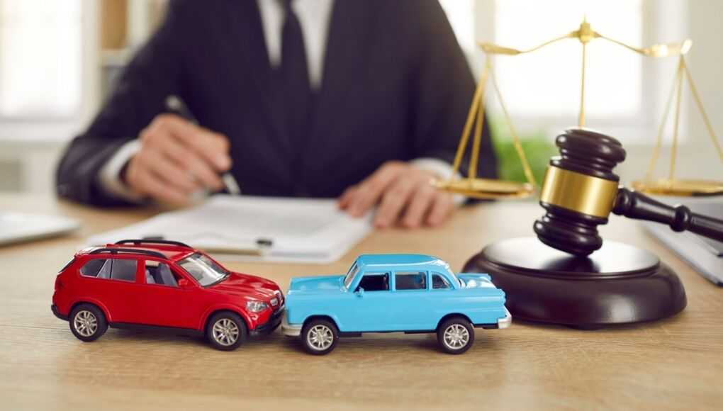 Lawyer analyzing documents with model cars and a gavel on desk, symbolizing a car accident lawsuit consultation