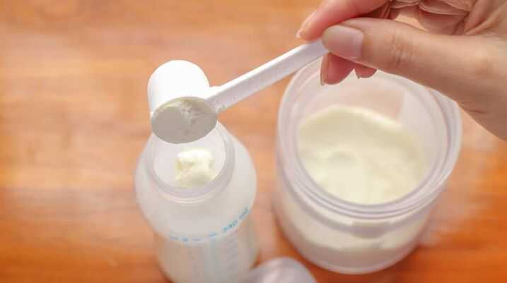 putting baby formula into a baby bottle