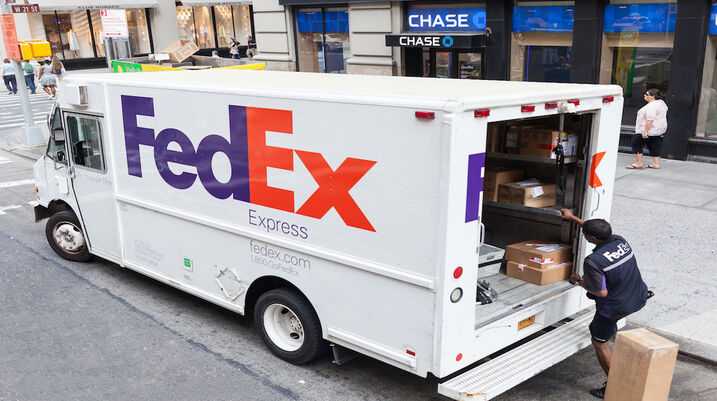 How Day Rates Keep FedEx Drivers From Overtime - Fedex driver taking packages from van