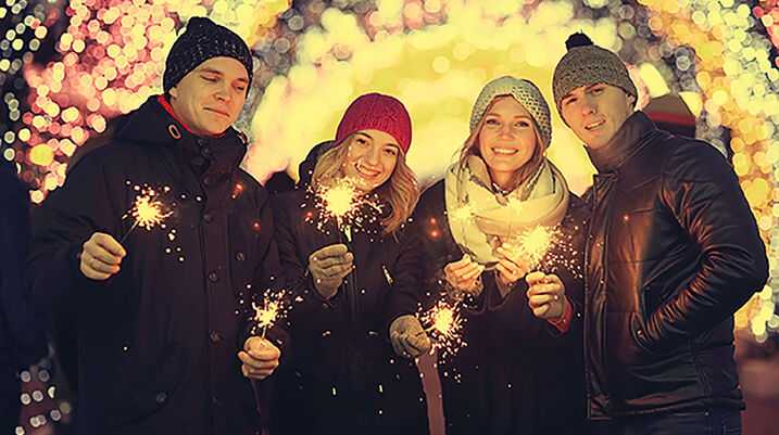 Four people surrounded by lights in winter