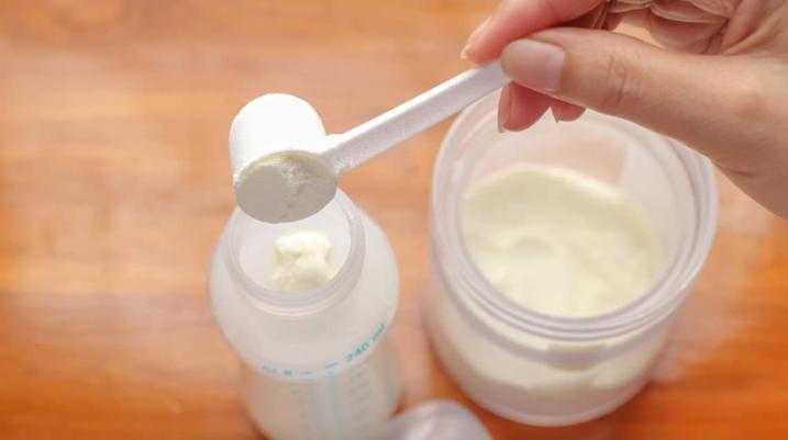putting baby formula into a baby bottle