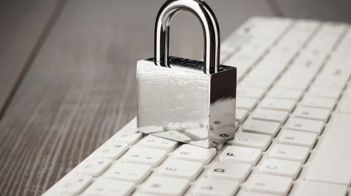 padlock and white computer keyboard on the wooden office table. privacy protection, encrypted connection concept