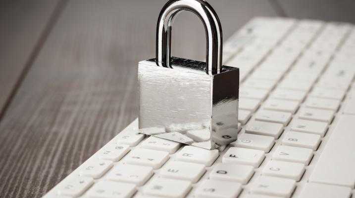 padlock and white computer keyboard on the wooden office table. privacy protection, encrypted connection concept
