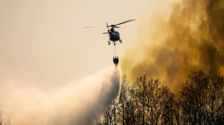 Helicopter watering fiery forest