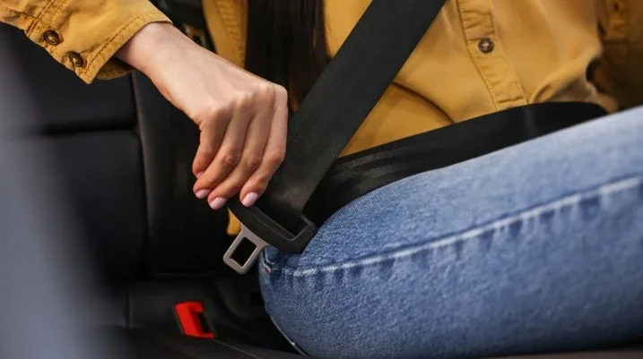 teenager putting on the seatbelt