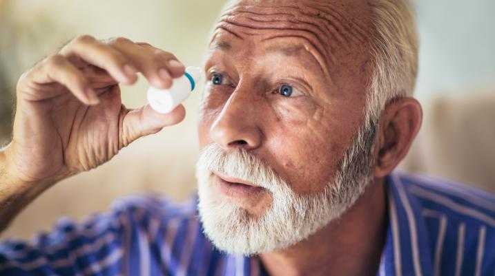 Man putting in eye drops
