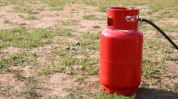 Red propane tank on the ground