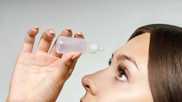 Woman putting in eye drops