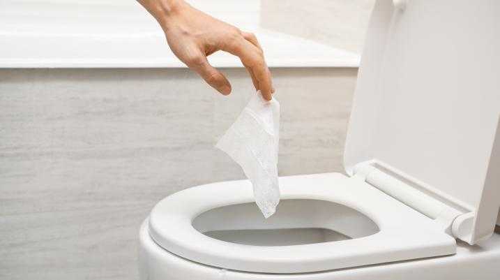 Someone throwing away toilet paper