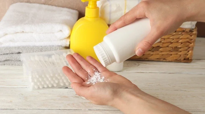 Person putting talcum powder in their hand