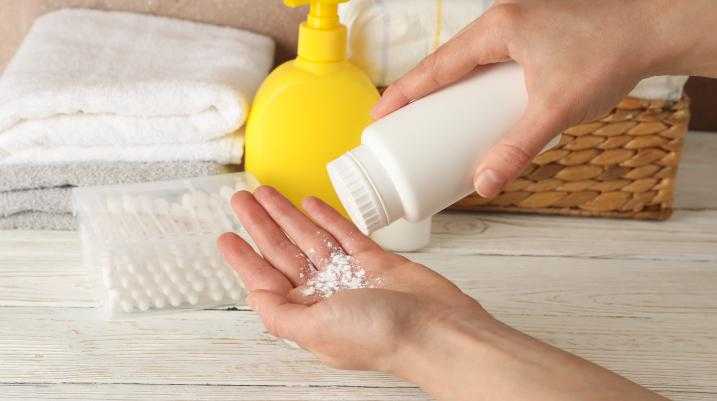 Person putting talcum powder in their hand