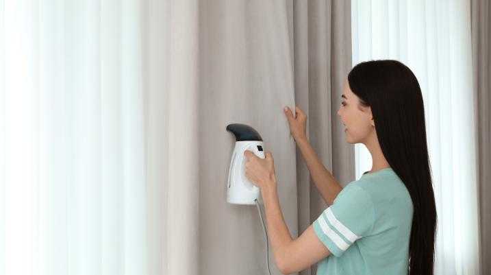 Woman steaming a curtain 