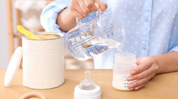 Woman making a baby bottle with baby formula