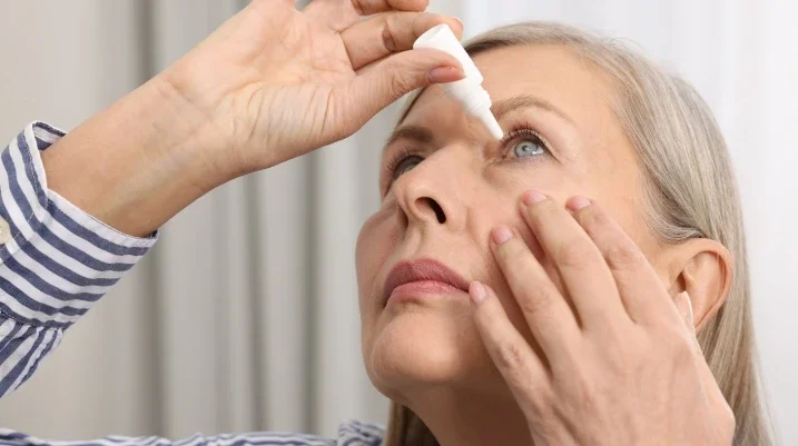 Woman putting in eye drops