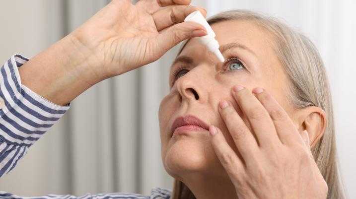 Woman putting in eye drops