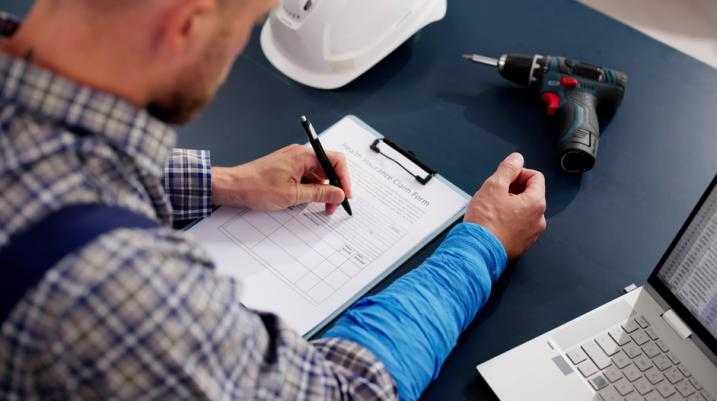 man signing workers' compensation forms