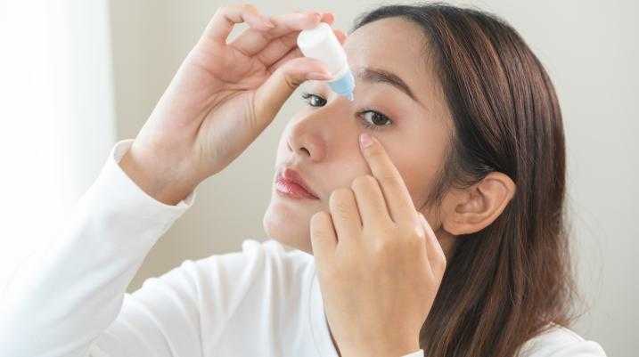 Woman putting in eye drops