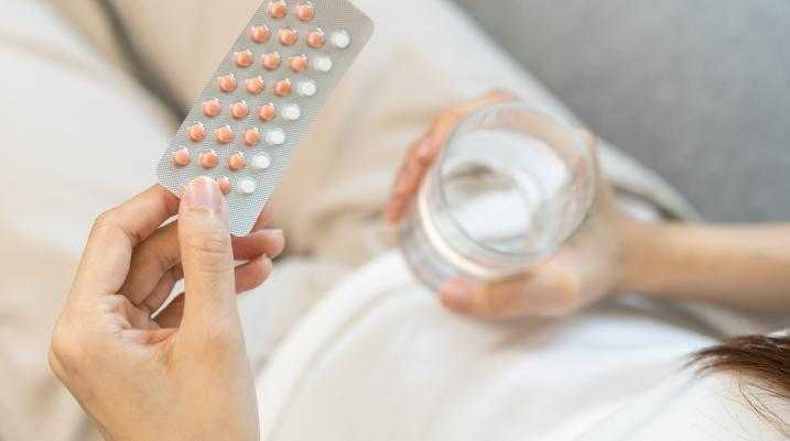 Woman holding birth control pills