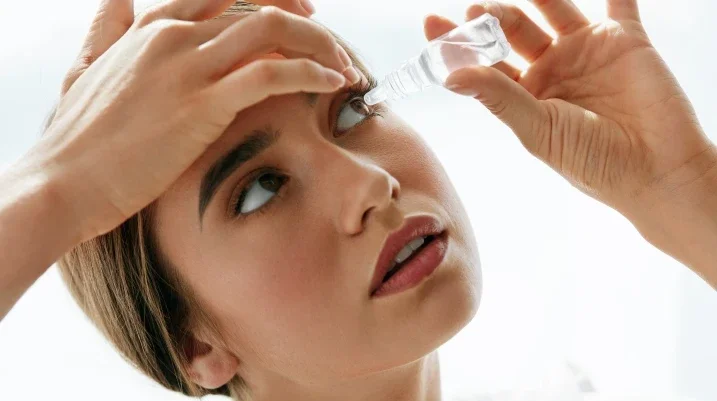 Woman putting in eye drops