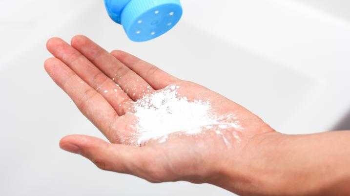 Person putting talcum powder in their hand
