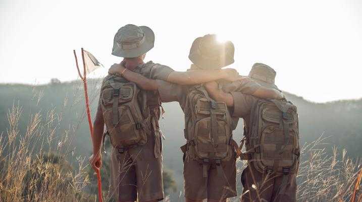 Three boy scouts hugging