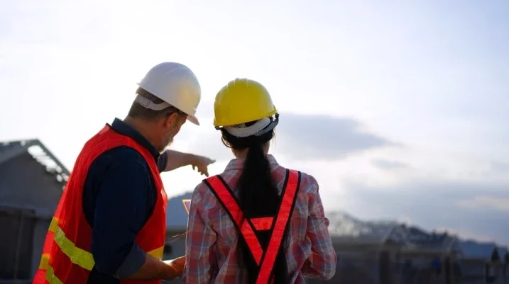 Construction worker helping another worker