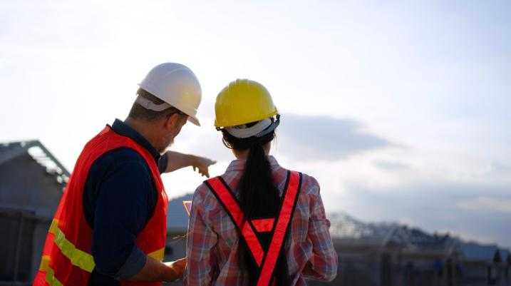 Construction worker helping another worker
