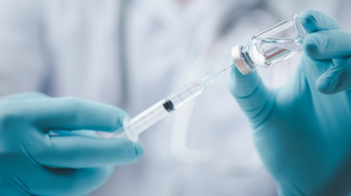 Medical professional using a syringe