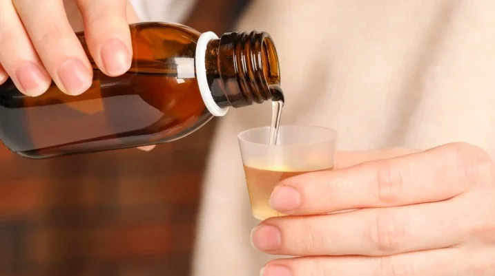 Woman pouring medication into cup